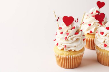 Sevgililer Günün kutlu olsun. Açık gri arka planda kalp şeklinde şekle sahip kapkekler, yakın plan. Metin için boşluk