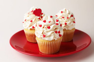 Sevgililer Günün kutlu olsun. Açık gri arkaplanda kalp şeklinde serpiştirilmiş lezzetli kekler, yakın plan.