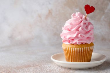 Sevgililer Günün kutlu olsun. Gri masadaki kırmızı kalpli lezzetli kek, yakın plan. Metin için boşluk