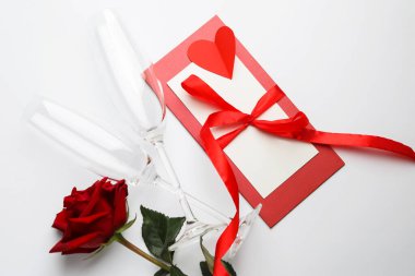 Sevgililer Günü. Gözlükler, zarf, kart, gül ve kırmızı kalp beyaz arka planda, düz yatıyordu