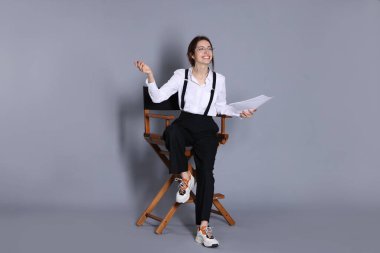 Senaryosu gri arka planda olan profesyonel film yönetmeni.