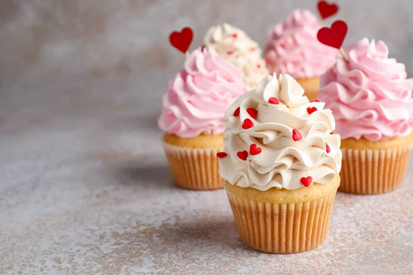 Sevgililer Günün kutlu olsun. Gri masada kırmızı kalpleri olan lezzetli kekler, yakın plan. Metin için boşluk