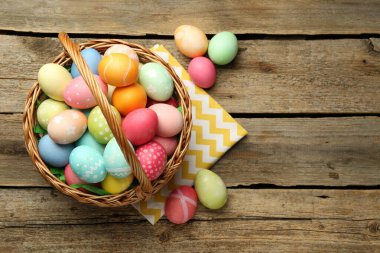 Tahta masanın üzerinde boyanmış yumurtalar olan Paskalya sepeti, düz yatıyordu. Metin için boşluk