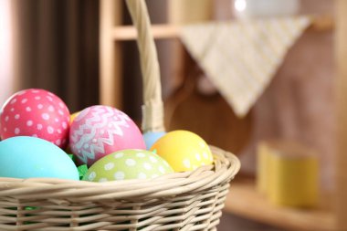 Paskalya sepetinin içinde kapalı bir masa üzerinde boyanmış yumurtalar, yakın plan. Metin için boşluk