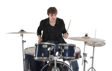 Elinde bagetlerle gülümseyen genç çocuk beyaz arka planda davul çalmayı öğreniyor.