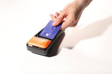 Kredi kartı olan bir adam beyaz arka planda ödeme terminalini kullanıyor.