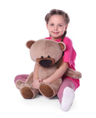 Beyaz arka planda oyuncak ayısı olan sevimli küçük bir kız.