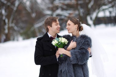 Yeni evli çiftimiz kış günü açık havada çiçek demetleriyle