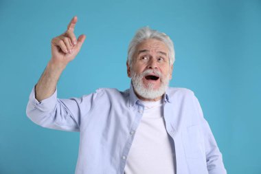 Hafıza kaybı. Kıdemli adam açık mavi arka planda bir şey hatırlıyor.