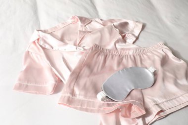 Şık pembe pijamalar ve uyku maskesi, yakın plan.