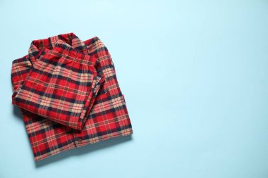 Açık mavi arka planda şık pijamalar, üst manzara. Metin için boşluk