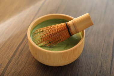 Seramik kasede taze yeşil kibrit ve ahşap masada bambu çırpıcı, yakın plan