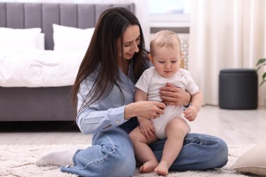 Annesi evde yerde tatlı küçük bebeğiyle.