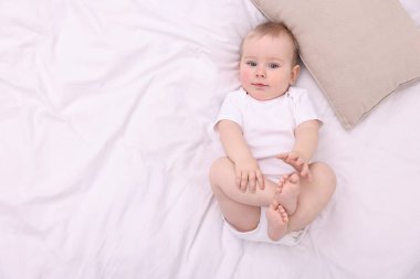 Evdeki yatakta uzanmış şirin küçük bebek, üst manzara. Metin için boşluk