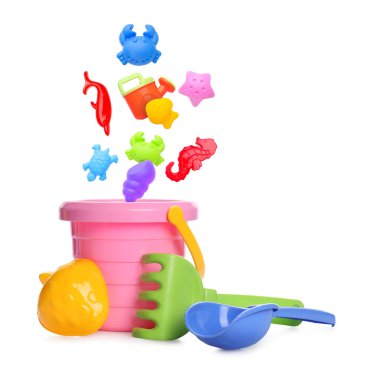 Çocuklar için plaj oyuncakları. Plastik kum kalıpları ve sulama kutusu beyaz arka planda kovaya düşer.