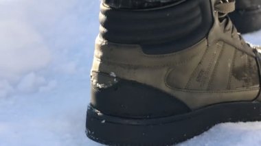 Açık havada güneş ışığında yürüyen bir adam, yakın plan. Kamera yukarı hareket ediyor