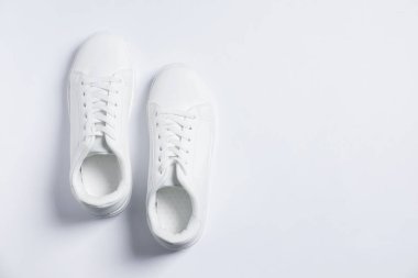 Beyaz arka planda bir çift şık spor ayakkabı, üst manzara. Metin için boşluk