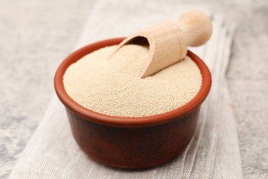 Kuru maya ve kapta kepçeyle gri masada yakın plan.