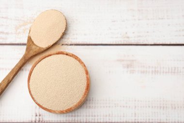 Kasede kuru maya ve beyaz ahşap masada kaşık, üst manzara. Metin için boşluk