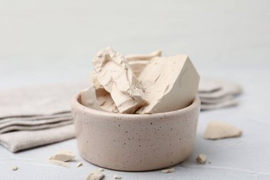 Beyaz masadaki kasede taze maya parçaları, yakın plan.