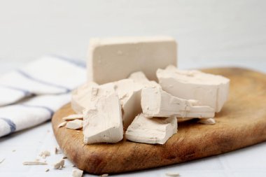 Beyaz döşeme üzerinde taze maya parçaları, yakın plan.