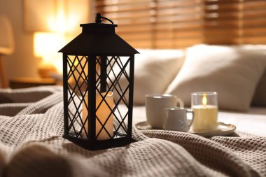 Güzel bir Noel feneri, yanan mumlar ve sıcak bir bardak içecekle birlikte.