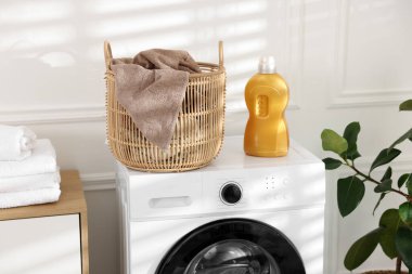 Çamaşır sepetinin içinde kirli havlu ve deterjan var.