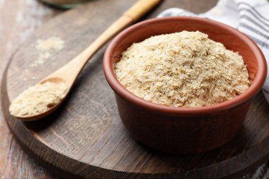 Kuru maya taneleri kasede ve kaşık tahta masada, yakın plan.