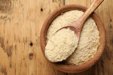 Kasede kuru maya taneleri ve tahta masada kaşık, üst manzara. Metin için boşluk