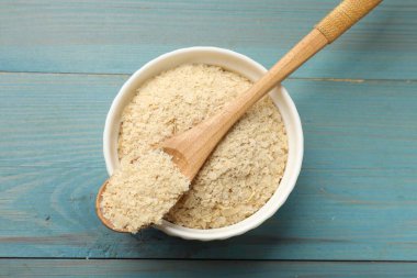 Kuru maya taneleri kasede ve kaşık açık mavi ahşap masada, üst manzara