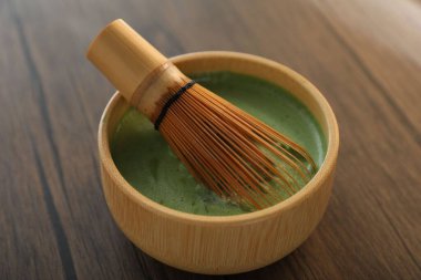 Seramik kasede taze yeşil kibrit ve ahşap masada bambu çırpıcı, yakın plan