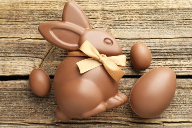 Çikolatalı Paskalya tavşanı ve yumurtalar ahşap masada, düz yatıyordu.