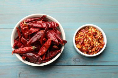 Kırmızı biber ve tanecikler açık mavi ahşap masa, düz uzanmış