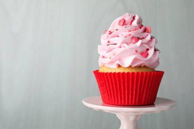 Sevgililer Günün kutlu olsun. Gri ahşap duvarın yanında serpiştirilmiş lezzetli kek, yakın plan. Metin için boşluk