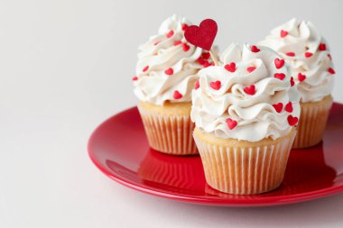 Sevgililer Günün kutlu olsun. Açık gri arkaplanda kalp şeklinde serpiştirilmiş lezzetli kekler, yakın plan.