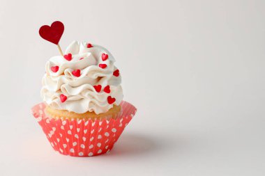 Sevgililer Günün kutlu olsun. Açık gri arka planda kalp şeklinde serpiştirilmiş lezzetli kekler, yakın plan. Metin için boşluk