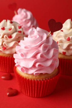 Sevgililer Günün kutlu olsun. Kırmızı arka planda kalpleri olan lezzetli kekler, yakın plan.