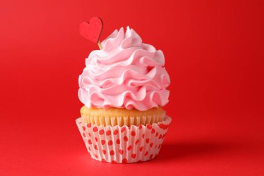 Sevgililer Günün kutlu olsun. Kırmızı arka planda kalp kaplaması olan lezzetli kek, yakın plan.