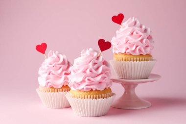 Sevgililer Günün kutlu olsun. Pembe arka planda kırmızı kalp kaplamalı lezzetli kekler, yakın plan.