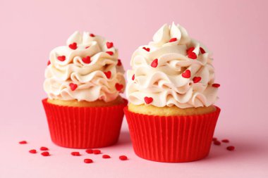 Sevgililer Günün kutlu olsun. Pembe arka planda kırmızı kalpleri olan lezzetli kekler, yakın plan.