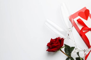 Sevgililer Günü. Gözlükler, zarf, kart, gül ve kırmızı kalp beyaz arka planda, düz yerde. Metin için boşluk