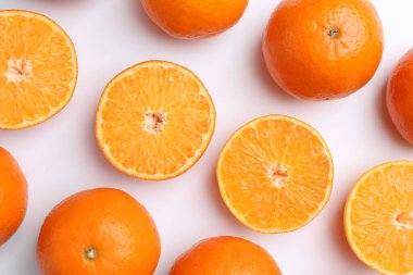 Beyaz arka planda taze taze mandalinalar, düz uzanmış.