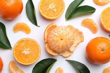 Taze, sulu mandalinalar ve beyaz arka planda yapraklar.