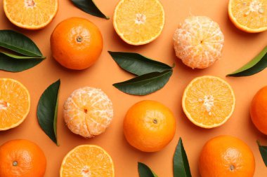 Taze taze mandalina ve turuncu arka planda yapraklar.