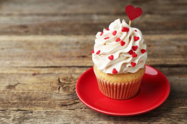 Sevgililer Günün kutlu olsun. Tahta masadaki kalpler şeklinde serpilmiş lezzetli kekler, yakın plan. Metin için boşluk