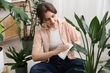 Evde yaprakları silen güzel bir kadın.