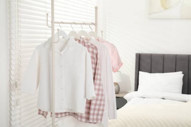 İçerideki yatağın yanındaki askıda asılı duran şık pijama gömlekler, metin için yer