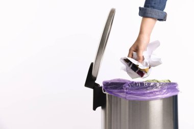 Beyaz arka plandaki çöp kutusuna kağıt atan kadın, yakın plan. Metin için boşluk