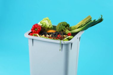 Çöpler açık mavi arka planda çöp kutusunda, yakın plan. Atık sıralama