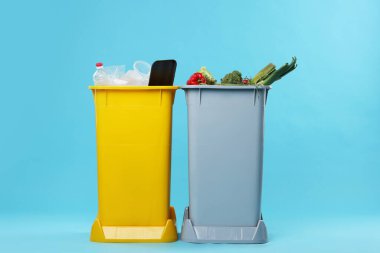 Açık mavi arka planda çöp kutuları. Atık sıralama